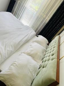 an unmade bed with pillows next to a window at KIGALi FANTASTIC STAY in Kigali