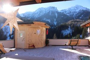 a large deck with a view of mountains at ALMRESIDENZ UNTERRAIN -1 km BY CAR DISTANCE SKI SLOPES KRONPLATZ in Valdaora