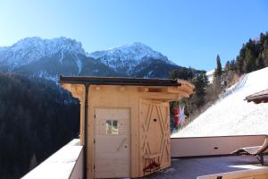 un petit bâtiment au sommet d'une montagne enneigée dans l'établissement ALMRESIDENZ UNTERRAIN -1 km BY CAR DISTANCE SKI SLOPES KRONPLATZ, à Valdaora