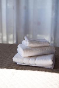 a stack of white towels sitting on a table at Villa Palmera 100m from the beach in Nikiti +48 photos