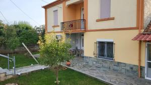 een huis met een kleine boom ervoor bij Αυλή της Ελιάς in Prosotsáni