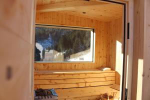 une vue intérieure d'un sauna en bois avec une fenêtre dans l'établissement ALMRESIDENZ UNTERRAIN -1 km BY CAR DISTANCE SKI SLOPES KRONPLATZ, à Valdaora