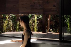 a woman in a black dress walking on a deck at 제주 감성숙소 스테이보스케 in Jeju