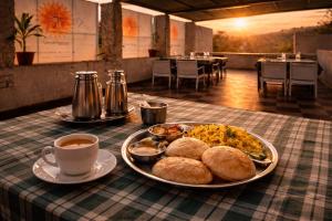 een tafel met een bord eten en een kopje koffie bij Ramma TheHotel - 200 mtrs from Nakki Lake in Mount Ābu +53 foto's