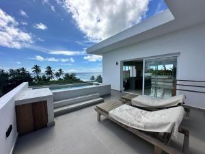 a white house with two beds on a balcony at Bahari View, Stylish Penthouse with breathtaking oceanviews and private rooftop pool in Kiwengwa