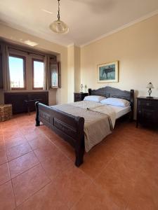 a bedroom with a large bed in a room at Villa Palmera 100m from the beach in Nikiti