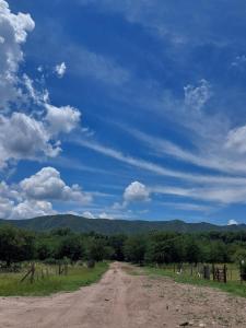 un chemin de terre au milieu d'un champ dans l'établissement Canaña Los Comechingones, à Santa Rosa de Calamuchita