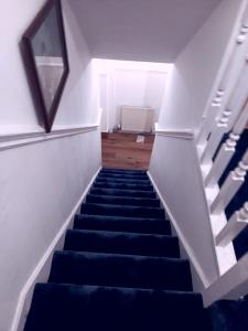 een trap met blauwe tapijttreden en een trap bij High class accommodations 10 in Little Hulton +2 foto's
