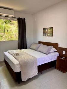 ein Schlafzimmer mit einem großen Bett und einem Fenster in der Unterkunft Pousada Dona Francisca in Florianópolis + 107 Fotos