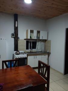 - une cuisine avec une table en bois et un plafond en bois dans l'établissement Canaña Los Comechingones, à Santa Rosa de Calamuchita