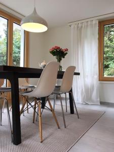 une table à manger avec des chaises et un vase de fleurs dans l'établissement Ferienhaus Grüner Heinrich, à Andermatt