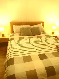 een slaapkamer met een groot bed met twee lampen bij High class accommodations 10 in Little Hulton
