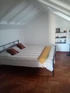 un letto grande in una stanza con pavimento in legno di bed and breakfast La Terrazza a Genova