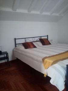 a large white bed in a room with wooden floors at bed and breakfast La Terrazza in Genoa