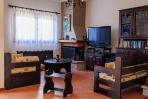 a living room filled with furniture and a flat screen tv at Villa Palmera 100m from the beach in Nikiti