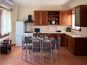 a kitchen with a table and chairs in it at Villa Palmera 100m from the beach in Nikiti