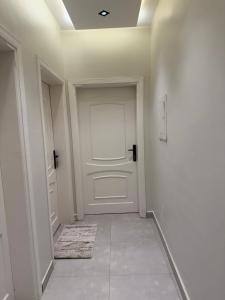 einen Flur mit einer weißen Tür und einem Teppich in der Unterkunft comfortable hotel Jeddah in Dschidda