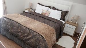 a bedroom with a large bed and a night stand at Durmitor Sunstone in Žabljak