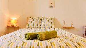 ein Schlafzimmer mit einem Bett mit grünen Handtüchern darauf in der Unterkunft Dréo - Spacieux avec terrasse in Brignoles
