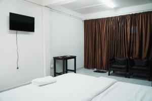a bedroom with a bed and a television on a wall at ROYALTY GLOBAL HOMESTAY in Shillong