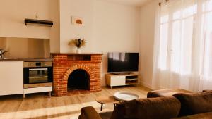 ein Wohnzimmer mit einem gemauerten Kamin und einem TV in der Unterkunft Dréo - Spacieux avec terrasse in Brignoles