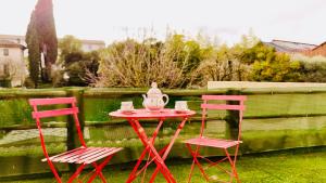 ein roter Tisch mit zwei Stühlen und einem Teekessel darauf in der Unterkunft Dréo - Spacieux avec terrasse in Brignoles