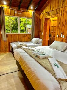 una fila di letti in una camera con pareti in legno di Cabanas Imbuia a Cambará Altre 43 foto