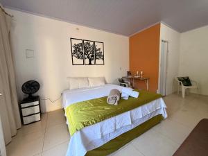 ein Schlafzimmer mit einem Bett mit grün-weißer Bettwäsche in der Unterkunft Caminito Brasília Hostel in Luziânia