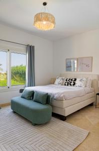 a bedroom with a bed and a couch and a chandelier at VESTA - El Gouna Residence in Hurghada +23 photos