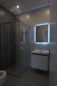een badkamer met douche, wastafel en toilet bij The Blue Wave Hotel in Himare +51 foto's