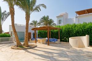a patio with two palm trees and a gazebo at VESTA - El Gouna Residence in Hurghada
