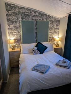 ein Teddybär, der auf einem Bett sitzt in der Unterkunft A and C Lodge Plot 21 2 double bedrooms PLOT 21 With HOT TUB 1 pet only No Commercial Vans 4pm check in in High Hesket