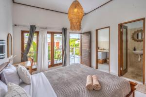una camera da letto con un letto con due pantofole sopra di Villa iris Homestay a Uluwatu Altre 65 foto