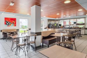ein Speisesaal mit Tischen und Stühlen in einem Restaurant in der Unterkunft Ace Hotel Roanne in Mably