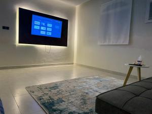 ein Wohnzimmer mit einem Flachbildfernseher an der Wand in der Unterkunft comfortable hotel Jeddah in Dschidda