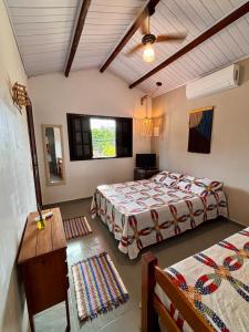 a bedroom with two beds and a table and a window at Suites e Casa_Pauba in São Sebastião +39 photos