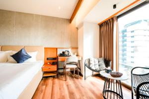 a hotel room with a bed and a table and chairs at Nestlay Suites by TC One in Kozhikode