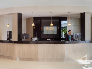 a man sitting at a counter in an office at Boutique Hotel H10 White Suites - Adults Only in Playa Blanca +53 photos