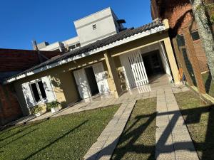 a house with a lawn in front of it at Conforto a 100 m do mar in Tramandaí