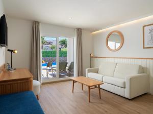 a living room with a couch and a table at Boutique Hotel H10 White Suites - Adults Only in Playa Blanca