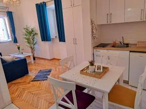 a kitchen and living room with a table and chairs at Old town nest in Budva