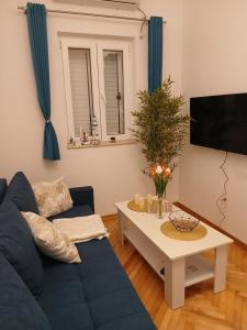 a living room with a blue couch and a table at Old town nest in Budva