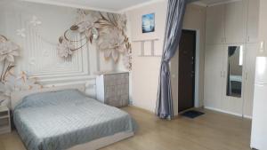 a bedroom with a bed and a flower wall at Современная студия-люкс, слобожанській in Samarovka