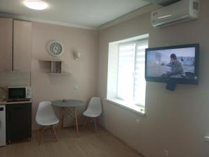 a living room with a tv hanging on a wall at Современная студия-люкс, слобожанській in Samarovka