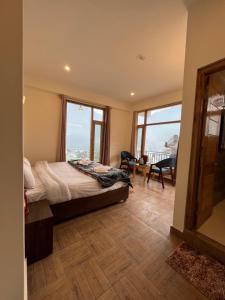 a bedroom with a bed and a large window at North star Manali in Vashisht +30 photos