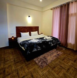 een slaapkamer met een bed met een houten hoofdeinde bij North Star Homestay Manali in Bashist