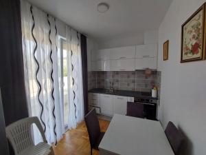 a kitchen with a table and chairs and a window at Andrej Apartment with Garage in Bar
