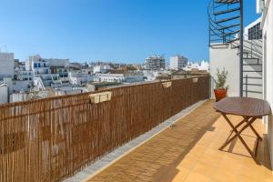 ein Balkon mit Tisch und Blick auf eine Stadt in der Unterkunft Downtown apartment - Terrace, garage and pool in Olhão