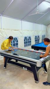 Twee mensen staan rond een pooltafel in een tent. bij Koh Ta Kiev Island Resort in Koh Ta Kiev