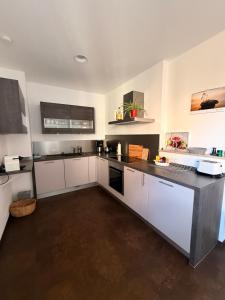 eine Küche mit weißen Schränken und einer schwarzen Arbeitsplatte in der Unterkunft Ferienwohnung Seetalblick in Geiselberg